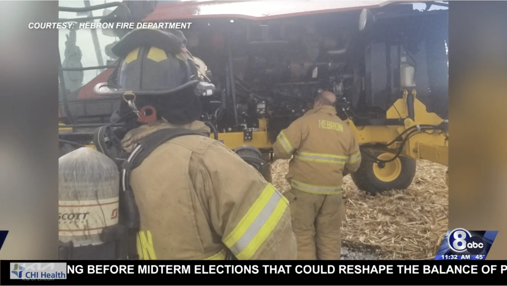 Two firefighters looking at tractor